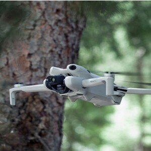 Dron DJI Mini 4 Pro en vuelo en el bosque