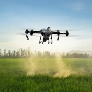 Dron agrícola DJI Agras T50 en pleno vuelo de pulverización sobre campo de cultivo visto de frente