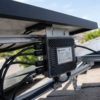 Microinversor solar instalado debajo de un panel fotovoltaico en un tejado