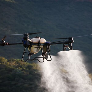 Dron agrícola DJI Agras realizando pulverización en un campo para agricultura de precisión.