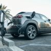 Coche eléctrico conectado a un poste de carga público mediante un cable Tipo 2