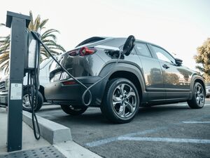 Coche eléctrico conectado a un poste de carga público mediante un cable Tipo 2